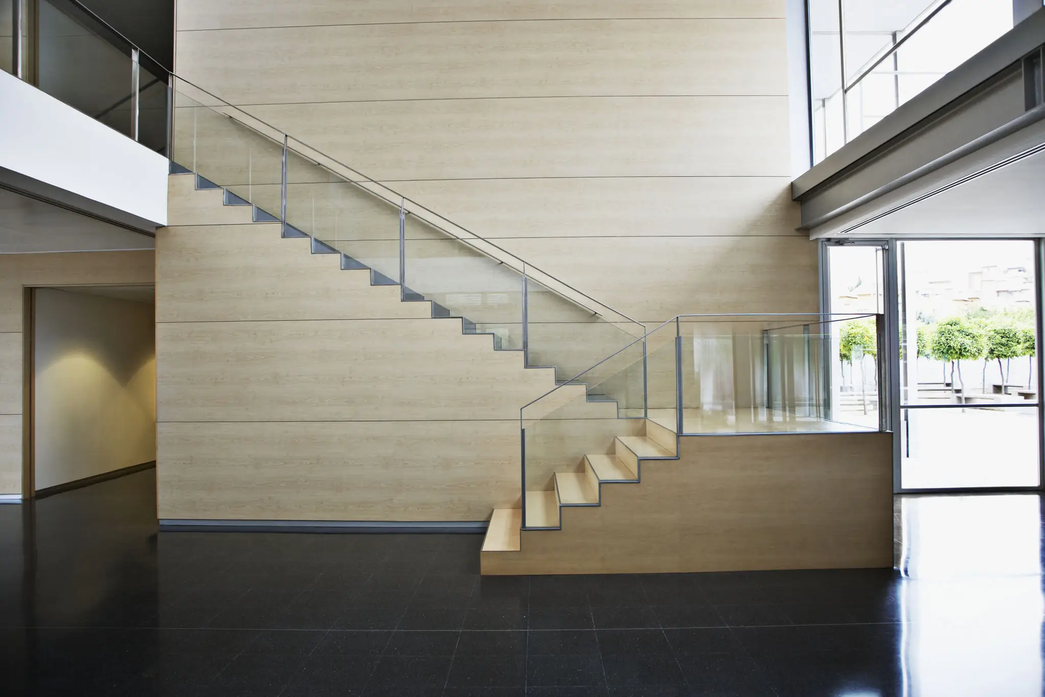Modern staircase with glass railing in a minimalist interior.